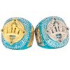 Gold and silver championship rings with crown designs, sparkling blue and white gems, labeled for champion and finalist.